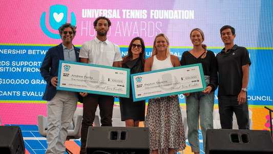 Players pose on stage with Hurd Award checks for $100,000.