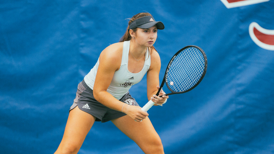 Women gets ready to return serve