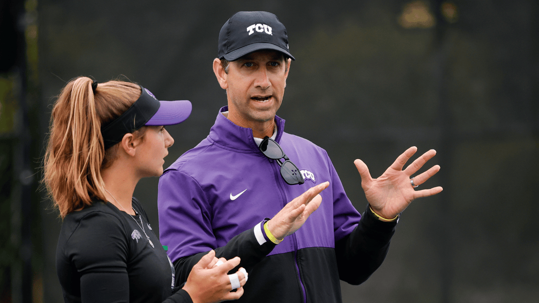 TCU men's tennis coach works with one of his players on court.