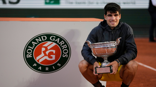 Carlos Alcaraz holds his first Roland Garros trophy.