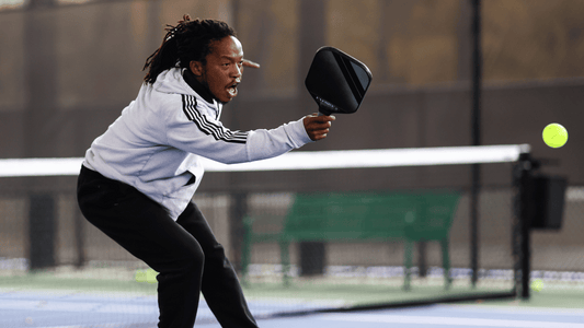 A man hits a pickleball.