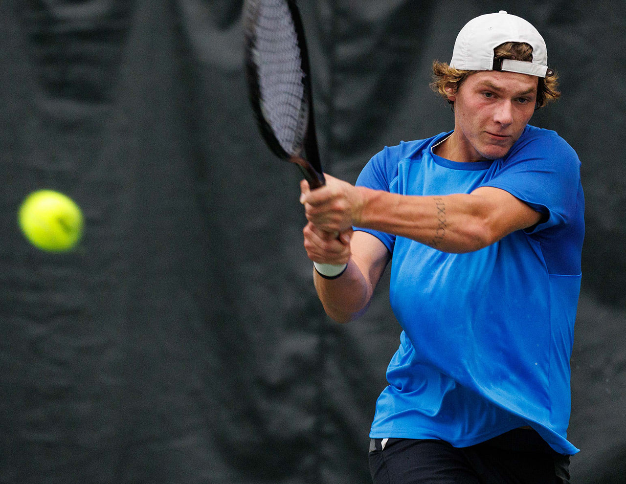 Tennis player with UTR Sports smashes a backhand while working on his UTR Rating